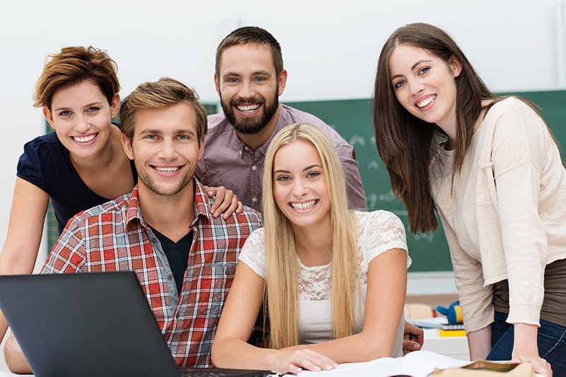 5 Lachende Studenten mit Laptop im Seminar